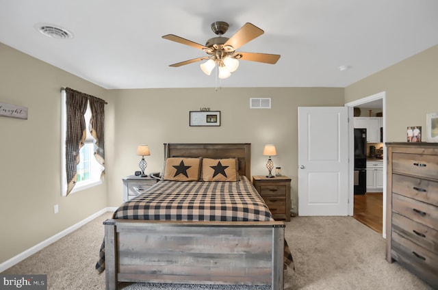 bedroom with black fridge, ceiling fan, and light colored carpet