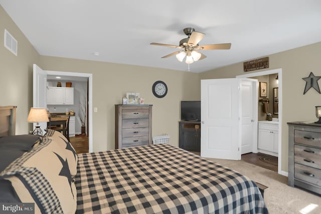 bedroom featuring ceiling fan, connected bathroom, and dark wood-type flooring