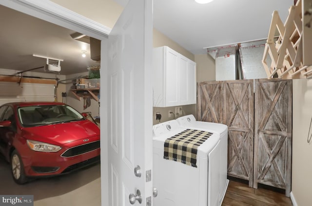 laundry room with washing machine and dryer, cabinets, and dark wood-type flooring