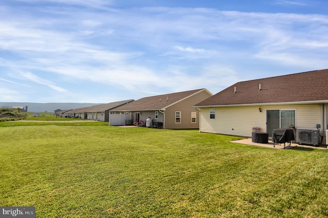 view of yard featuring central AC and a patio