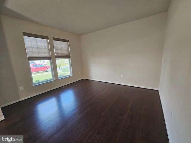 unfurnished room with dark wood-type flooring