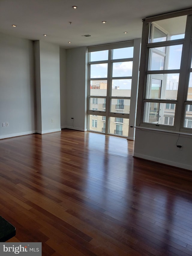 unfurnished room featuring dark hardwood / wood-style floors and expansive windows