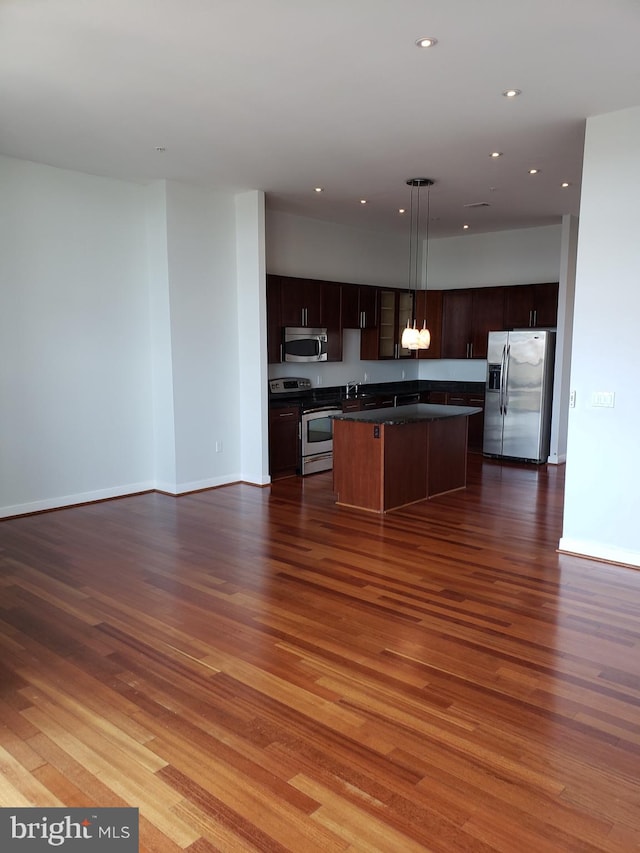 kitchen with dark brown cabinetry, a center island, hardwood / wood-style floors, and appliances with stainless steel finishes