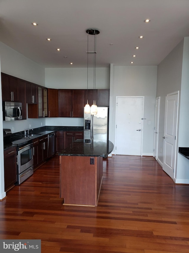 kitchen featuring a center island, dark hardwood / wood-style flooring, appliances with stainless steel finishes, pendant lighting, and sink