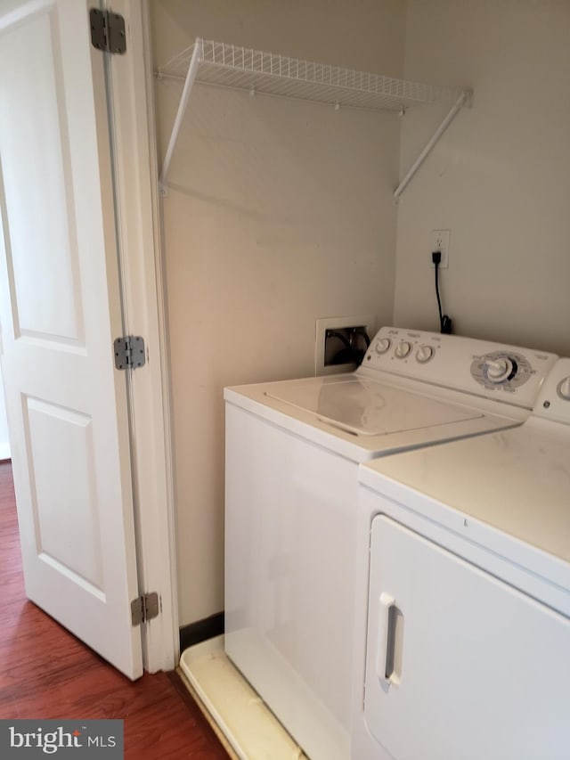 laundry area featuring wood-type flooring, separate washer and dryer, and washer hookup