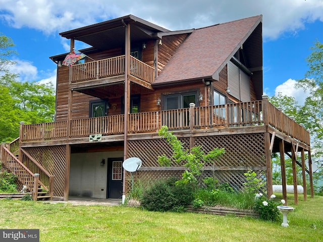 back of property with a balcony and a lawn