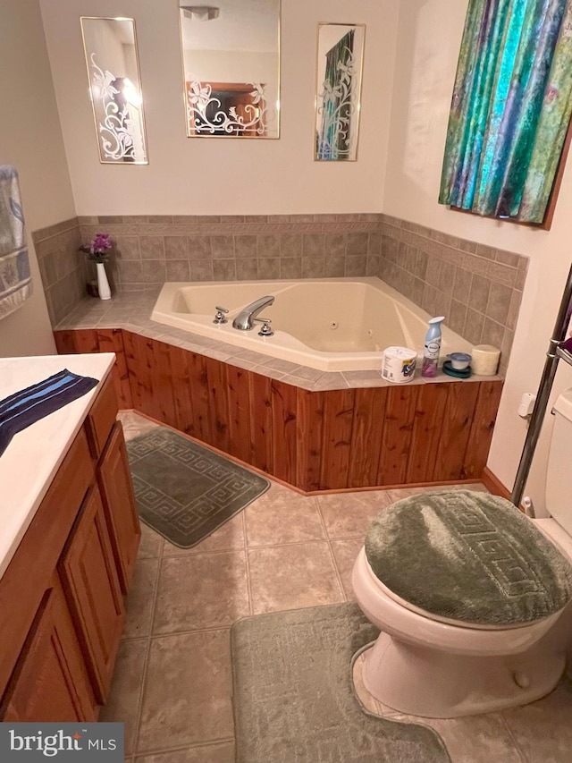 bathroom featuring tile patterned flooring, vanity, a relaxing tiled tub, and toilet