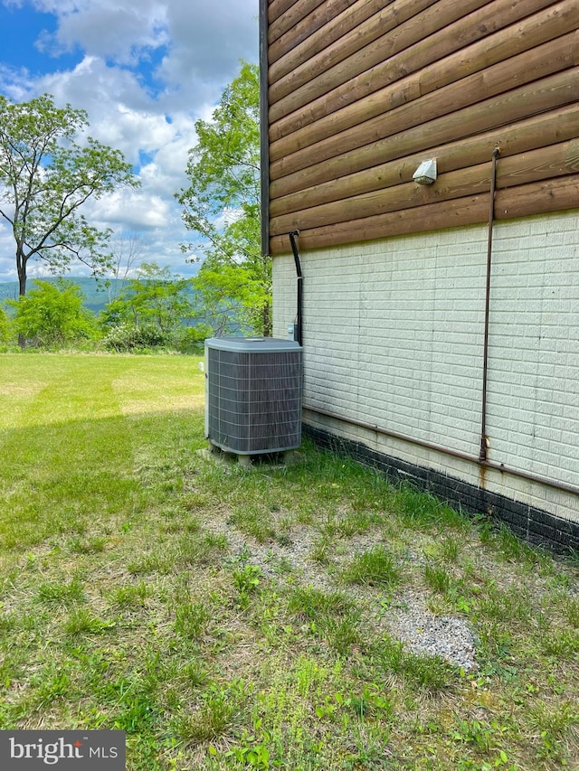 view of property exterior with a yard and central air condition unit