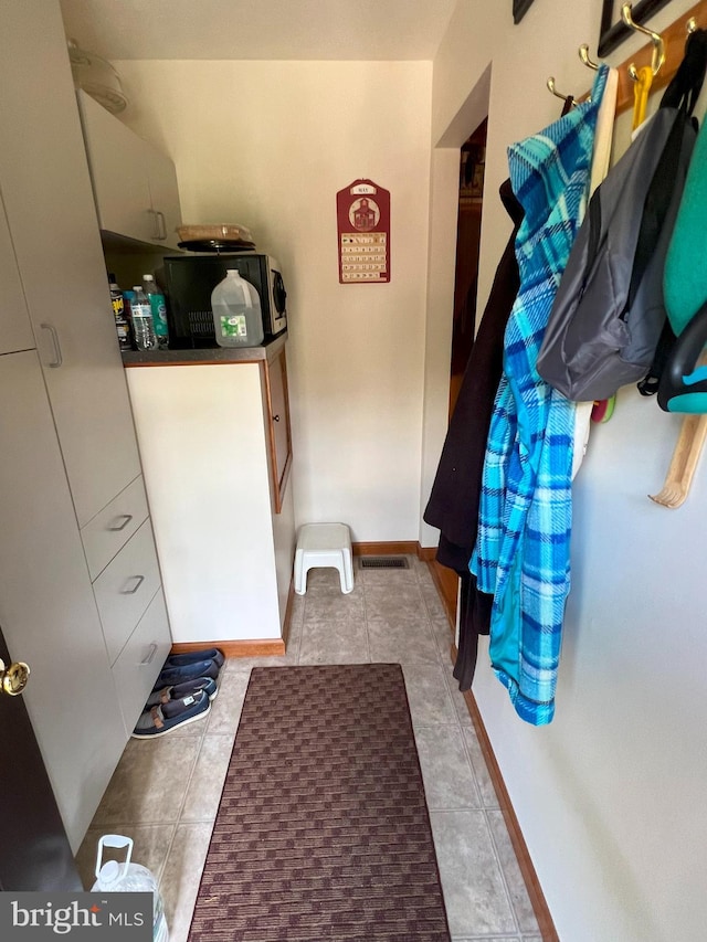 laundry area with light tile patterned floors