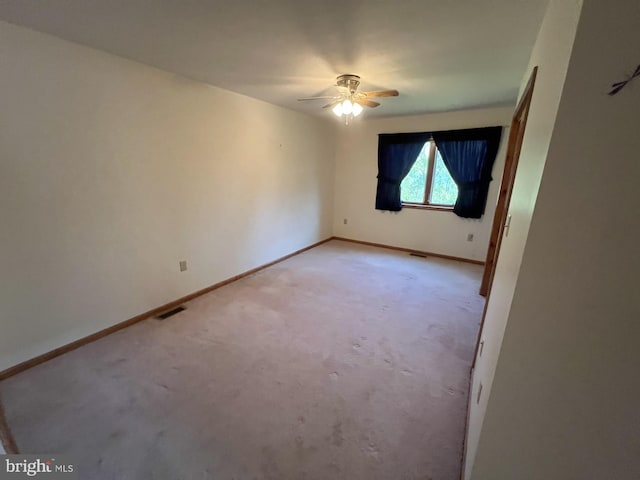 empty room featuring carpet floors and ceiling fan