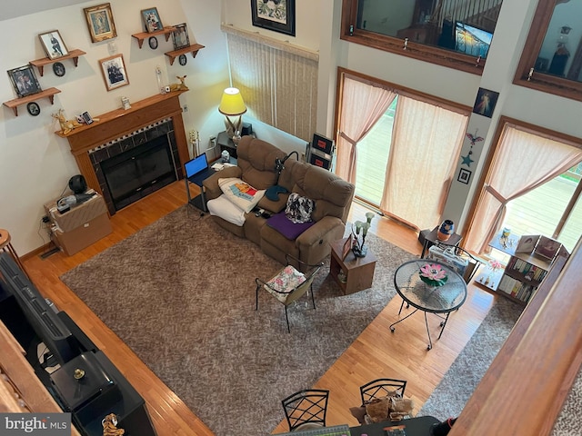 living room with a towering ceiling and hardwood / wood-style flooring