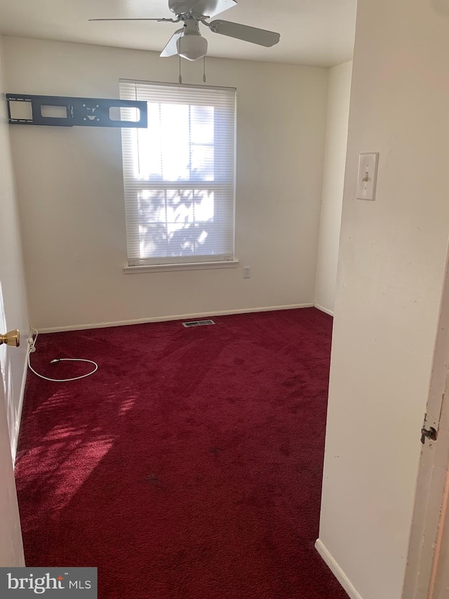 carpeted spare room featuring ceiling fan