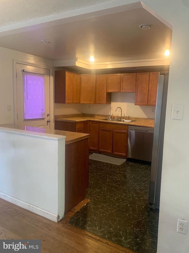 kitchen featuring appliances with stainless steel finishes, sink, kitchen peninsula, and dark hardwood / wood-style floors