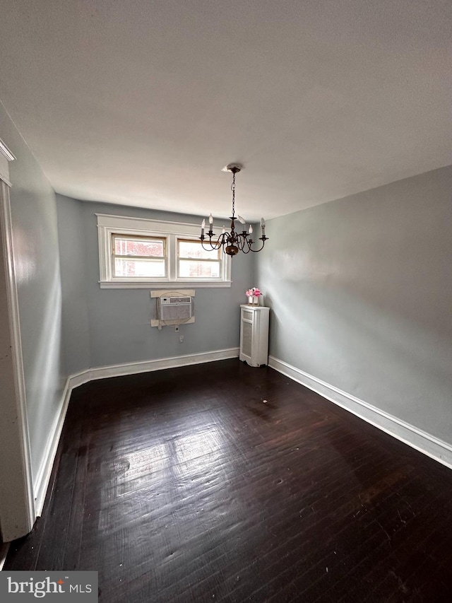 interior space featuring a notable chandelier, a wall unit AC, and dark hardwood / wood-style floors