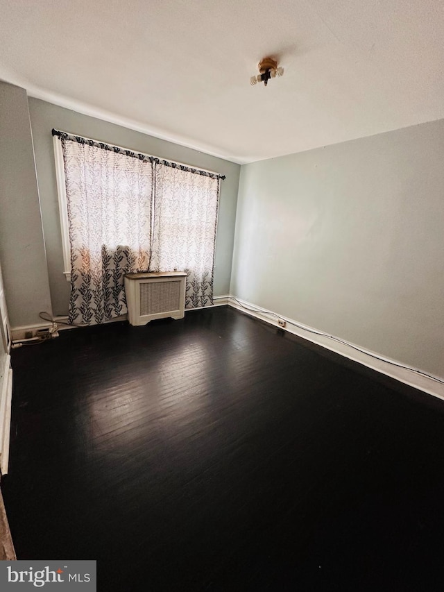 empty room with dark wood-type flooring