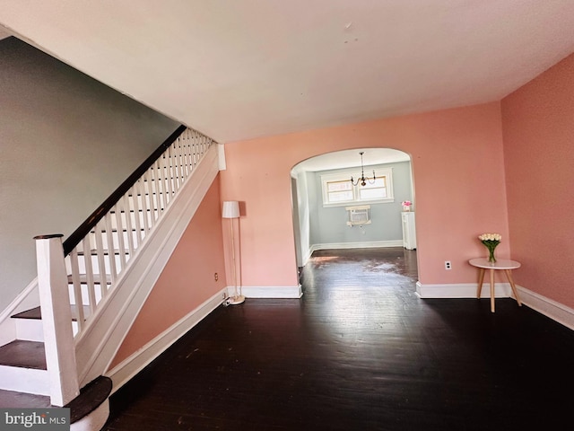 stairs with dark hardwood / wood-style flooring and a chandelier