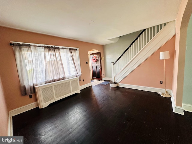 foyer featuring dark wood-type flooring and radiator heating unit