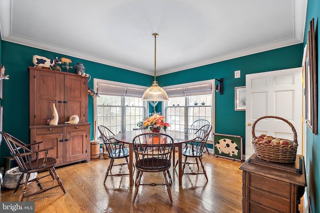 dining space featuring light hardwood / wood-style flooring and crown molding