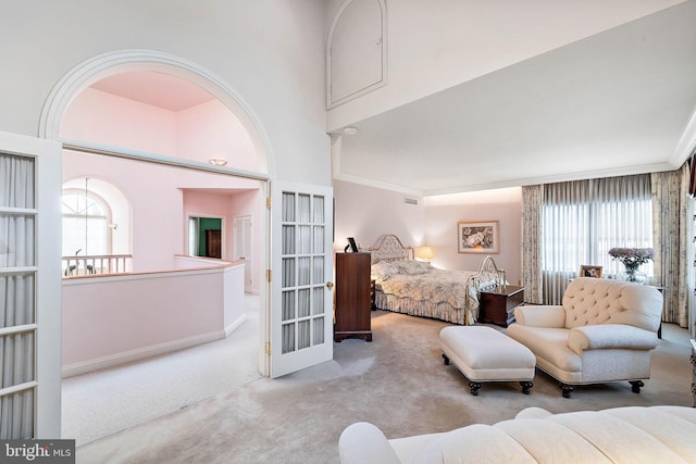 bedroom with a towering ceiling, carpet floors, and crown molding