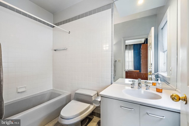 full bathroom featuring tile walls, toilet, tiled shower / bath, and oversized vanity