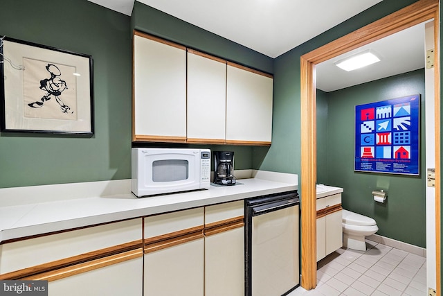 bathroom featuring tile flooring, vanity, and toilet