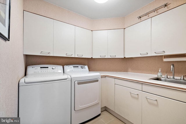 washroom featuring independent washer and dryer, sink, cabinets, and light tile floors