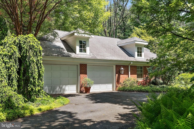 cape cod home featuring a garage