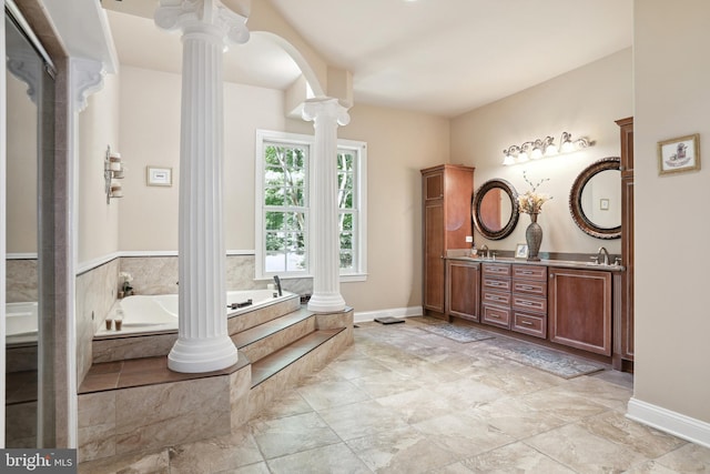 bathroom with dual vanity, tile flooring, a relaxing tiled bath, and ornate columns