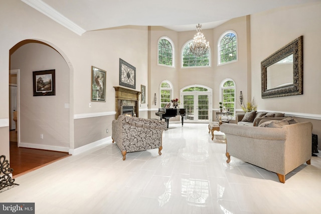 living room featuring a notable chandelier, a high ceiling, light tile flooring, and crown molding