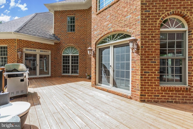 wooden deck featuring a grill