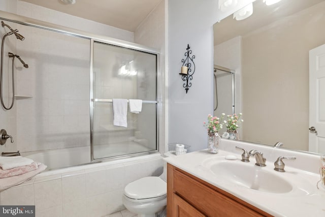 full bathroom with enclosed tub / shower combo, tile floors, vanity, and toilet