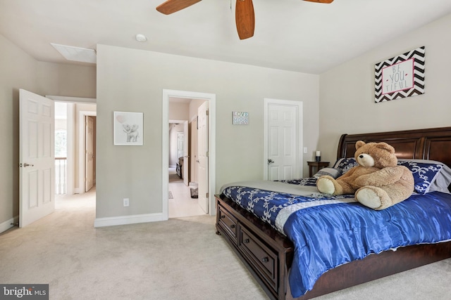 carpeted bedroom with ensuite bathroom and ceiling fan