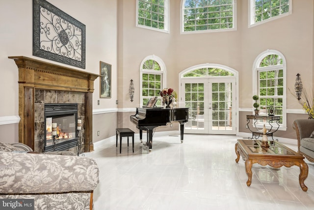 tiled living room with a towering ceiling and french doors