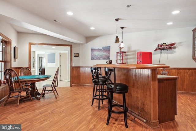 bar featuring light hardwood / wood-style floors and pendant lighting