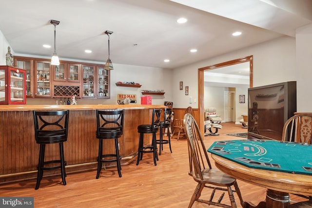 dining area with bar area and light wood-type flooring