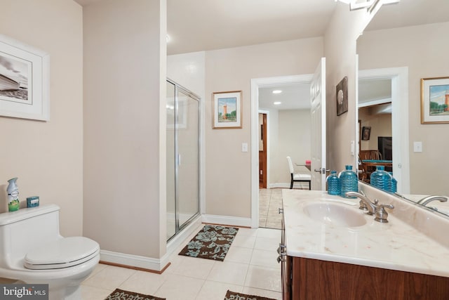 bathroom featuring tile floors, toilet, a shower with shower door, and oversized vanity