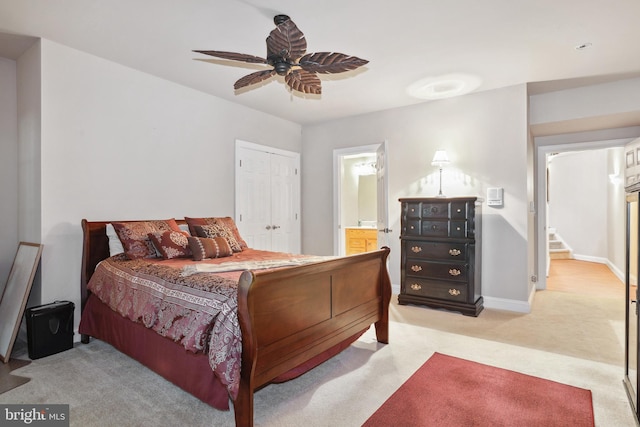 bedroom featuring light colored carpet, ensuite bathroom, a closet, and ceiling fan