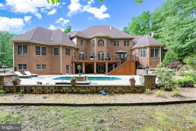 rear view of property with a pool side deck and a patio area