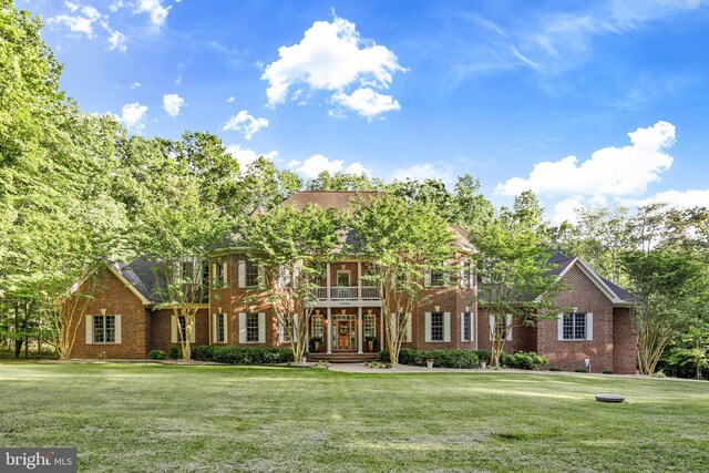 colonial home featuring a front lawn