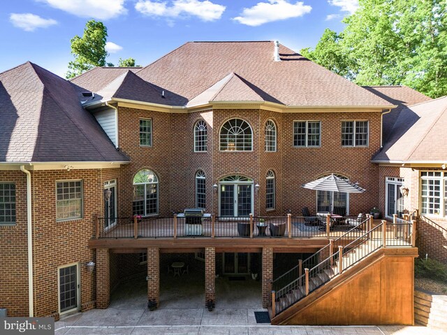 rear view of house featuring a patio area and a wooden deck