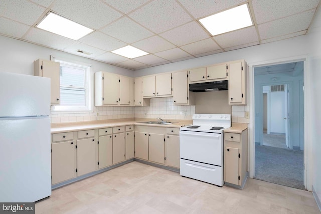 kitchen with white appliances, sink, backsplash, and a drop ceiling