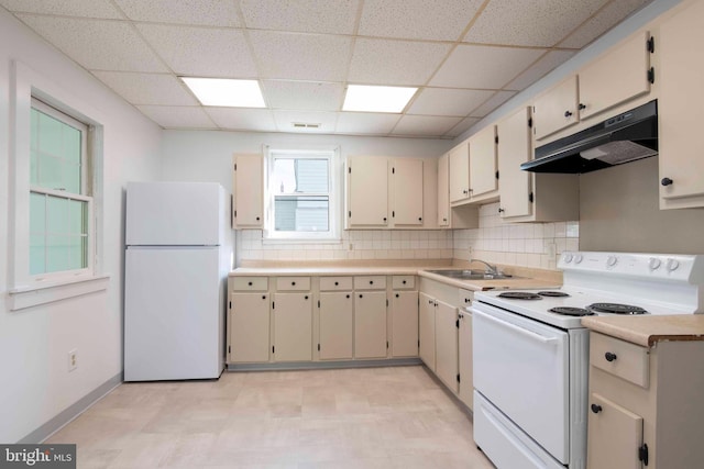 kitchen featuring white appliances, a drop ceiling, sink, tasteful backsplash, and light tile flooring