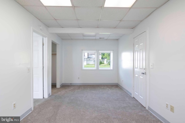 empty room featuring carpet floors and a drop ceiling