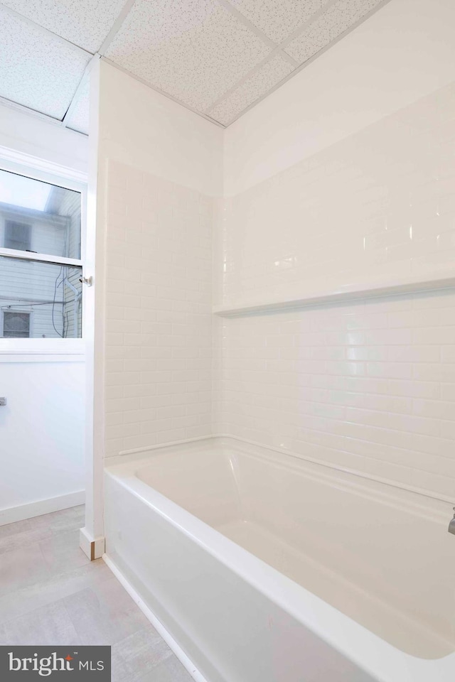 bathroom featuring tile flooring, a paneled ceiling, and tub / shower combination