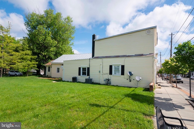 back of property with a lawn and central air condition unit