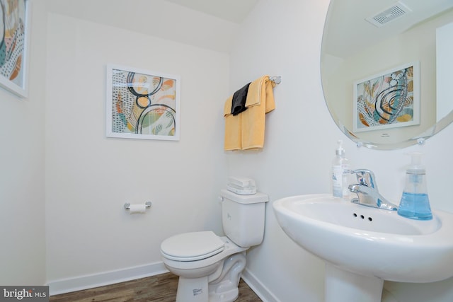 bathroom featuring sink, toilet, and wood-type flooring