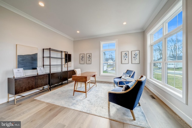 living area featuring ornamental molding and light hardwood / wood-style flooring