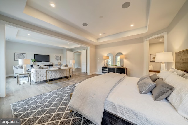 bedroom with a raised ceiling and hardwood / wood-style flooring