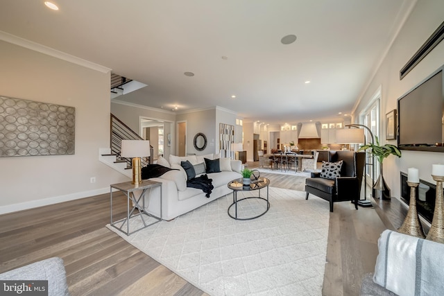 living room with crown molding, a healthy amount of sunlight, and light wood-type flooring