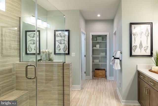 bathroom featuring walk in shower, tile flooring, and vanity